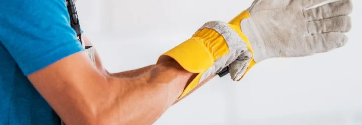 Person zieht Arbeitshandschuh an